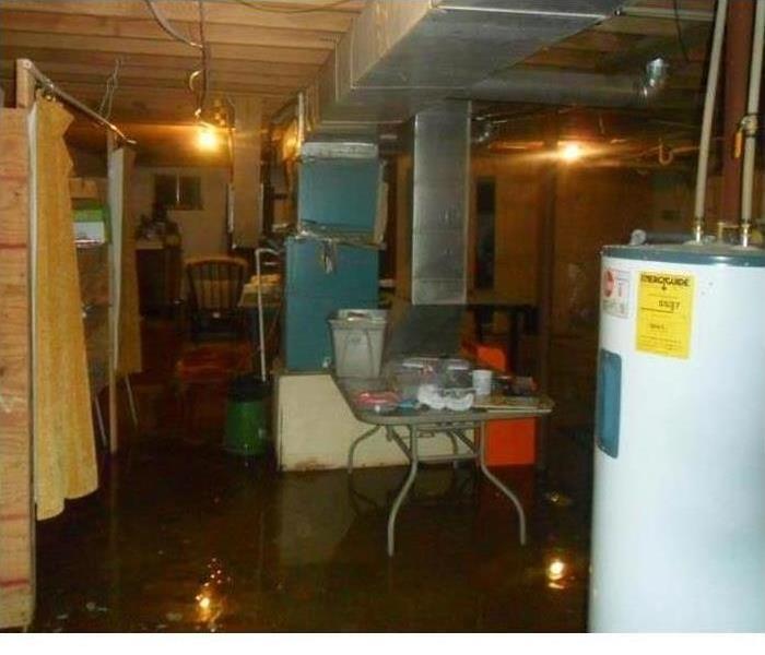 Basement with various contents and the floor is flooded