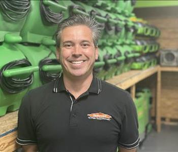 James is in a black SERVPRO polo shirt with a SERVPRO green background