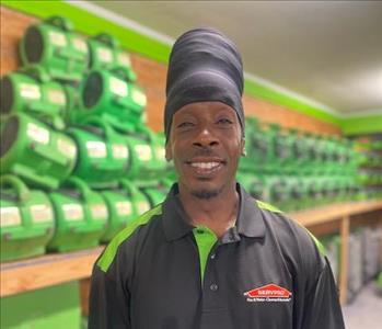 Sevpro employee in a black polo in front of a green background