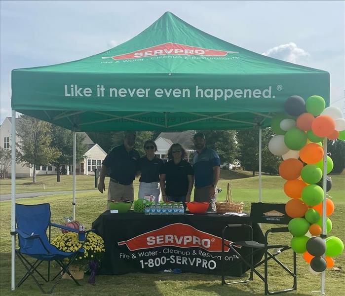4 SERVPRO team members pictured in the SERVPRO tent that was sponsoring a part of the golf tournament